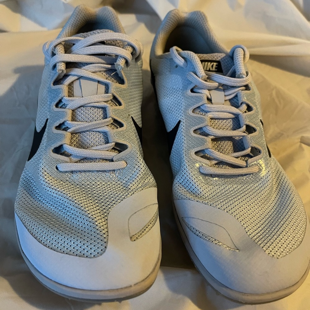 Silver Nike track cleats with bag and tool